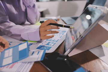 Close up ux developer and ui designer brainstorming about mobile app interface wireframe design on table with customer breif and color code at modern office.Creative digital development agency.