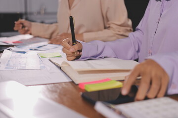 Close up ux developer and ui designer brainstorming about mobile app interface wireframe design on table with customer breif and color code at modern office.Creative digital development agency.
