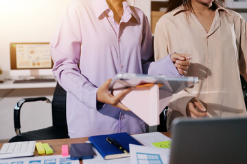 Close up ux developer and ui designer brainstorming about mobile app interface wireframe design on table with customer breif and color code at modern office.Creative digital development agency.