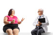 © Ljupco Smokovski - Overweight woman talking to a male doctor and sitting on a blank panel