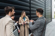 © Srdjan - IT experts freelance workers innovative technology developers, working on a new project staff meeting with casual talk in formalwear outside office building before the work. Discussing business people