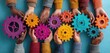 © Putra - Hands of diverse people hold colorful gears, symbolizing teamwork, collaboration, and unity on blue