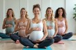 © Pete - Five pregnant women practice yoga, meditate together in bright studio. Sit cross-legged on mats, smiling with hands resting on bellies, enjoying calm, supportive class focused on wellness, motherhood.