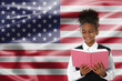 © New Africa - Little girl with book against flag of USA. Language school