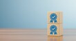 © Assetian - Two wooden blocks with blue award ribbons and checkmarks