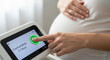 © Ben - Pregnant woman monitoring contractions on a digital device during pregnancy