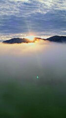 Wall Mural - Vertical View Of Sea Of Clouds With Mountain Peaks At Sunset. Aerial Shot