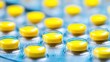 © MaiStock - Rows of small yellow tablets packed inside transparent blister pack