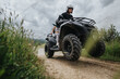 © qunica.com - A thrilling adventure of two friends riding an ATV along a dirt path, surrounded by lush greenery and cloudy skies, showcasing a sense of exploration, excitement, and connection with nature.