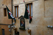 Façade d'immeuble de la ville de Sienne avec une icone de Vierge à l'enfant avec une oie encadrée de deux drapeaux