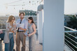 © qunica.com - People engaged in discussion outdoors on a rooftop under sunset lighting. They are reviewing documents in a casual and collaborative environment, emphasizing creativity, and innovation in business.