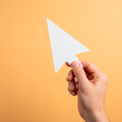 © Inna - Hand holding paper mouse cursor symbolizing digital interaction in creative environment