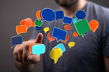 Conceptual image showing a man reaching out to connect with colorful speech bubbles, representing online communication and social networks.