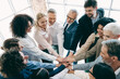 © deagreez - Diverse office team collaborating with hands together during business meeting, symbolizing unity, teamwork, and corporate collaboration