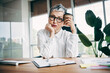 © deagreez - Mature businesswoman in a professional office setting holding a coffee cup while reflecting on decisions and workload challenges