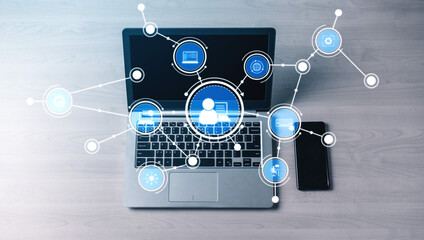 A modern laptop sits on a wooden surface, surrounded by digital icons that represent connectivity and communication in today tech-driven workspace. Tessel