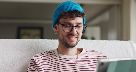 Glasses, tablet and man in home with research for education, learning or college application. Happy, planning and male person on sofa with digital technology for student loan in living room at house.