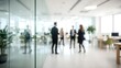 © Asawin - An abstract, blurred image of a modern office space, showing several people interacting