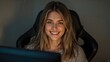 © The 2R Artificiality - Smiling young woman with long blonde hair seated in a computer chair in a dimly lit room, looking directly at the camera with a joyful expression.