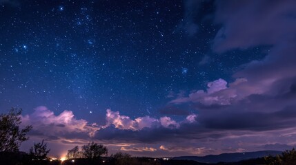 Wall Mural - The sky is filled with clouds and stars, creating a serene and tranquil atmosphere. The clouds are scattered throughout the sky, with some appearing closer to the horizon and others higher up