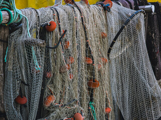 Fishing nets with floats and ropes drying on wooden rack