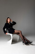 © Svetlana - Elegant woman in black outfit posing confidently in a minimalist studio setting