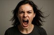 © Bijac - Young woman shouting on clean studio background with dramatic lighting portrait