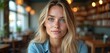 © Vadym - Young woman with blonde hair blue eyes poses. Beautiful natural female person smiles indoors. Portrait of attractive woman in a cafe setting or at home.