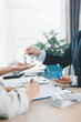 © doidam10 - Close up of real estate agent handing house key to client with contract paperwork, calculator and house models on desk, concept of home ownership, mortgage loan, property investment and success.