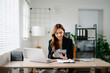 © Nuttapong punna - Business woman using tablet and laptop for doing math finance on an office desk, tax, report, accounting, statistics, and analytical research concept in office