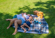 © Ekaterina - Mother hugs her sons while lying on a blanket during a summer picnic in a lush green park, enjoying a beautiful day outdoors, demonstrating closeness and quiet leisure time together