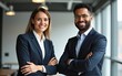© nana - Happy smiling confident professional mature Latin business man and Asian business woman colleagues corporate managers standing in office, two diverse executives team laughing arms crossed, portrait.