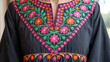 © Md Babul Islam - Close-up of vibrant floral embroidery adorning a traditional dark dress neckline, featuring colorful stitchwork and intricate patterns on ethnic attire