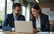 © wang - Its up to both of us to bring the results. Shot of a young businessman and businesswoman using a laptop in a modern office. High quality