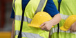 © amorn - Diversity factory worker standing holding helmet in factory. Male and female worker wearing safety uniform at work factory. Unity and teamwork concept