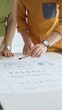 © rogerphoto - Business professionals analyzing financial reports, pointing at data points on charts and graphs lying across white desk surface