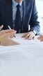 © volha_r - Businessman signing a contract papers at the white desk in office, colleagues applauding to the successful results of negotiations. Business people concept