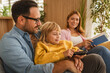 © Miljan Živković - Happy family relaxing together on sofa at home
