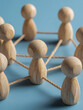 © Daria - Wooden figures connected with ropes forming a network symbolizing teamwork collaboration and interconnected communication on a blue surface background