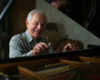 © YULIA - An elderly man with gray hair tunes a piano with a joyful expression, acoustics, craft, musical art.