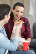 © auremar - man feeds his girlfriend pizza at home