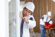 © auremar - construction worker building new house and fitting window