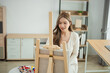 © WMSTUDIO - Young woman painting on an easel in a bright, modern studio filled with natural light, showcasing creativity and artistic expression in a serene environment.