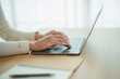 © WMSTUDIO - Close-up of Hands Typing on a Laptop Keyboard in a Bright and Modern Workspace with Natural Light Filtering through Window