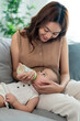 © Kawee - Asian beautiful mother holding and feeding baby from milk bottle.
