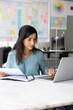 © fizkes - Busy young Latin project manager woman checking paper documents