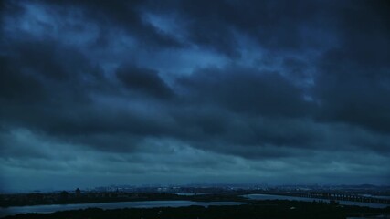 Wall Mural - Time lapse of dark stormy clouds over the seaside city