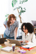 © Studio Marmellata - Two young women collaborate on a project, one typing on a laptop while the other leans in to discuss ideas.