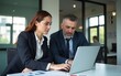 © nian - CEO mentoring a trainee on financial operations using a laptop in a modern office. A great shot for showcasing professional guidance and corporate training. High quality