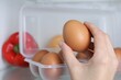 © New Africa - Woman taking raw chicken egg from fridge, closeup